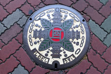 岸和田市の花「バラ」と「岸和田城」がデザインされたマンホールの蓋。