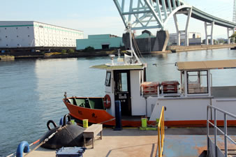 渡船と木津川に架かるアーチ型の「木津大橋」